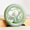 Round pale green jade pendant with a nine-tailed fox carved inside the ring