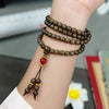 Wooden mala of 108 beads wrapped several times around a wrist