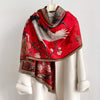 Red shawl scarf printed with a white crane and plum blossoms, draped over a white coat on a mannequin
