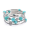 Multi-layer silver tone bracelet with round turquoise beads and geometric charms