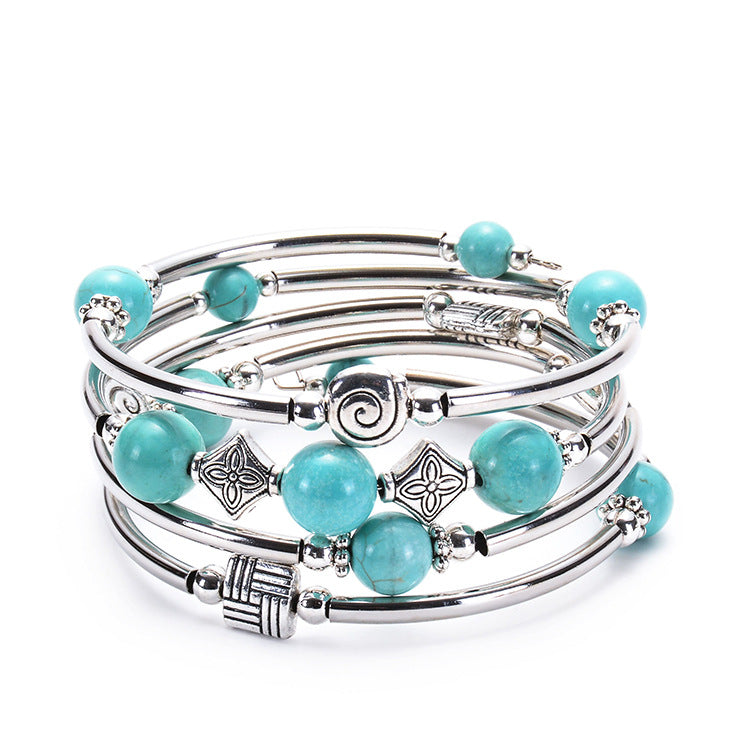 Multi-layer silver tone bracelet with round turquoise beads and geometric charms
