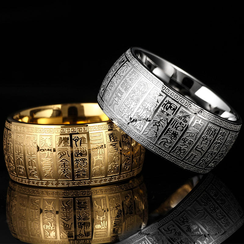 Two wide band rings with engraved characters, one in gold tone and one in silver tone