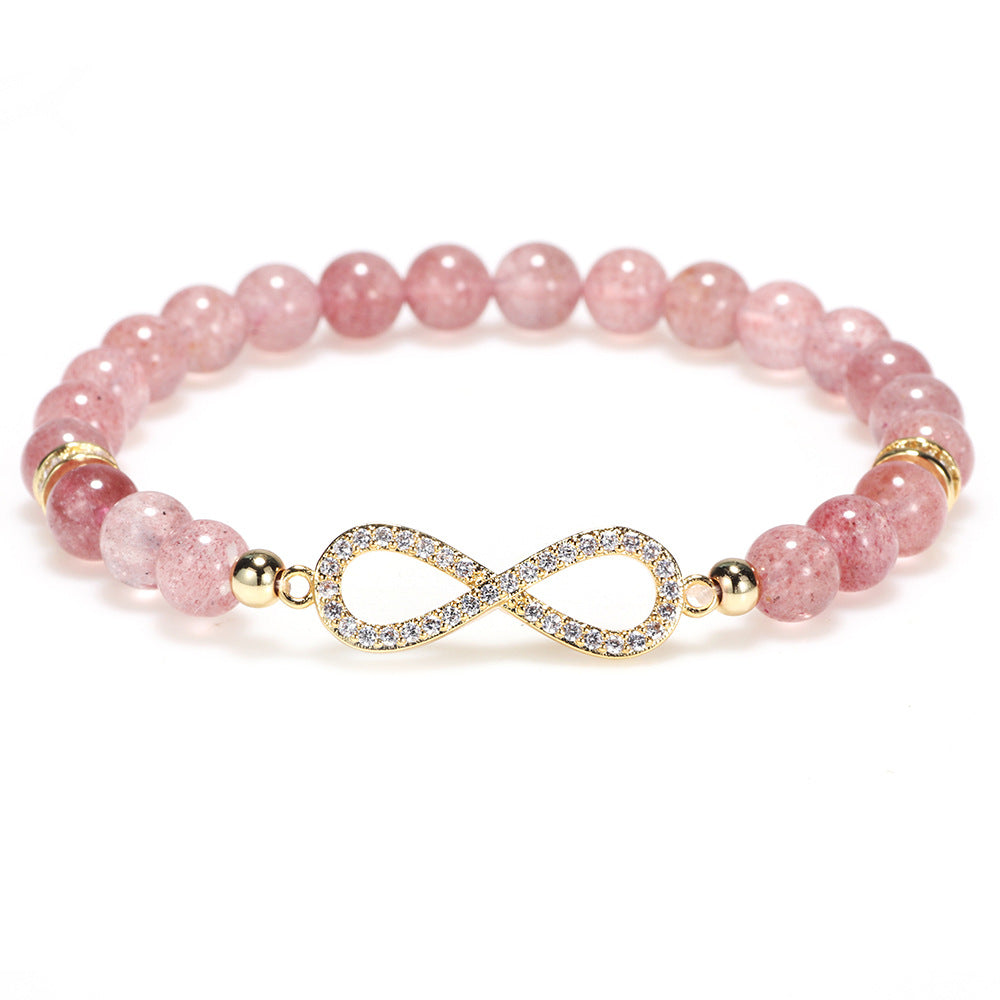 Pink Strawberry Quartz beaded bracelet with gold infinity symbol on a wrist