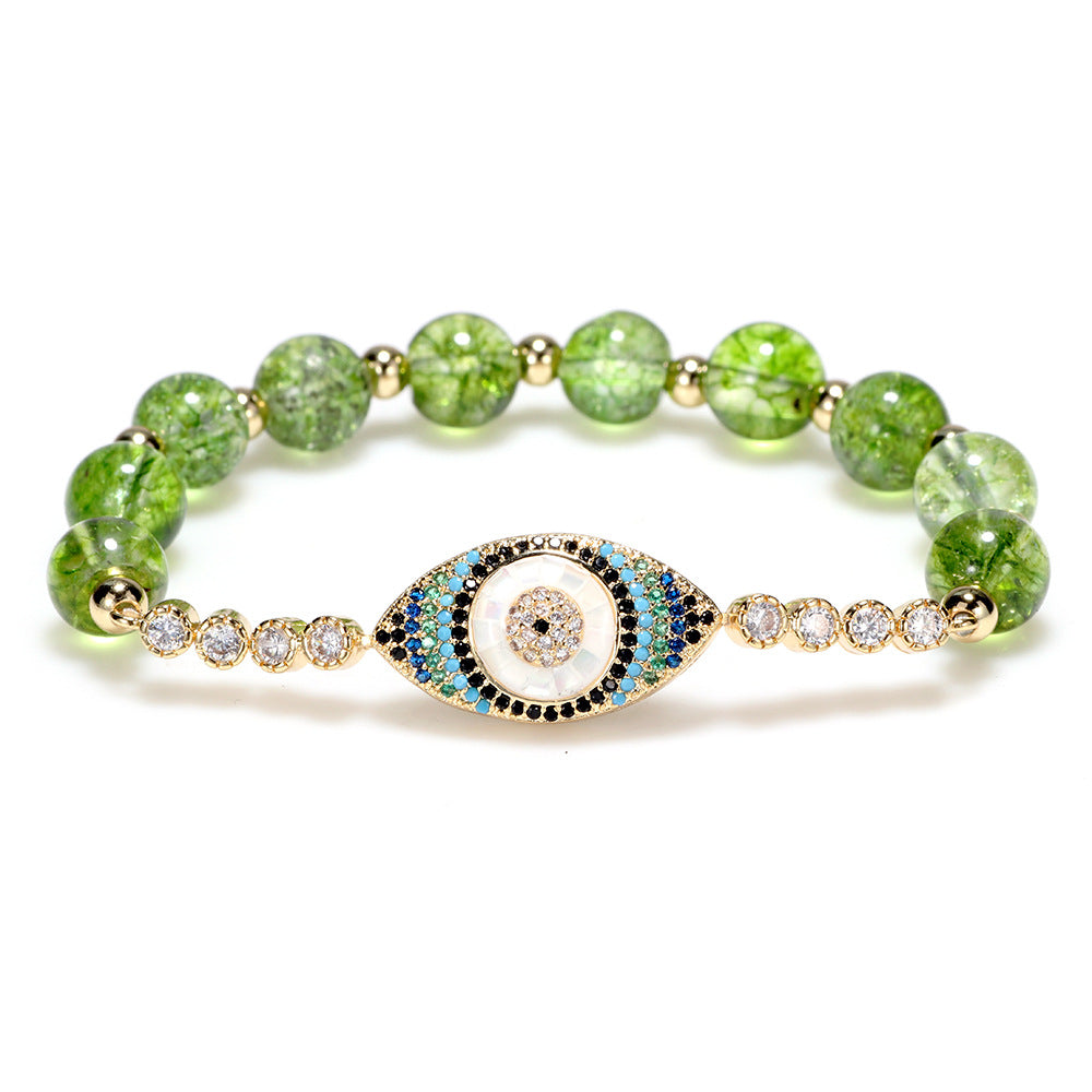 Olive green crystal bracelet with gold evil eye charm on white background