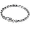 Close up of a twisted sterling silver bracelet with a lobster clasp and vajra charm on a dark surface