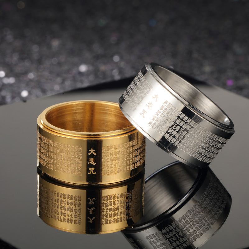 Close up of a gold tone and silver tone rotating ring with mantras engraved on the surface