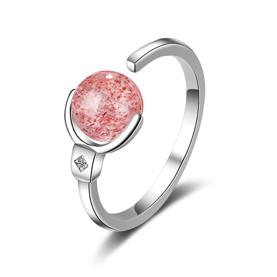Close up of a white tone ring with a rotating pink crystal sphere