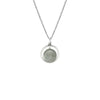 Woman wearing a silver necklace with a round moonstone pendant