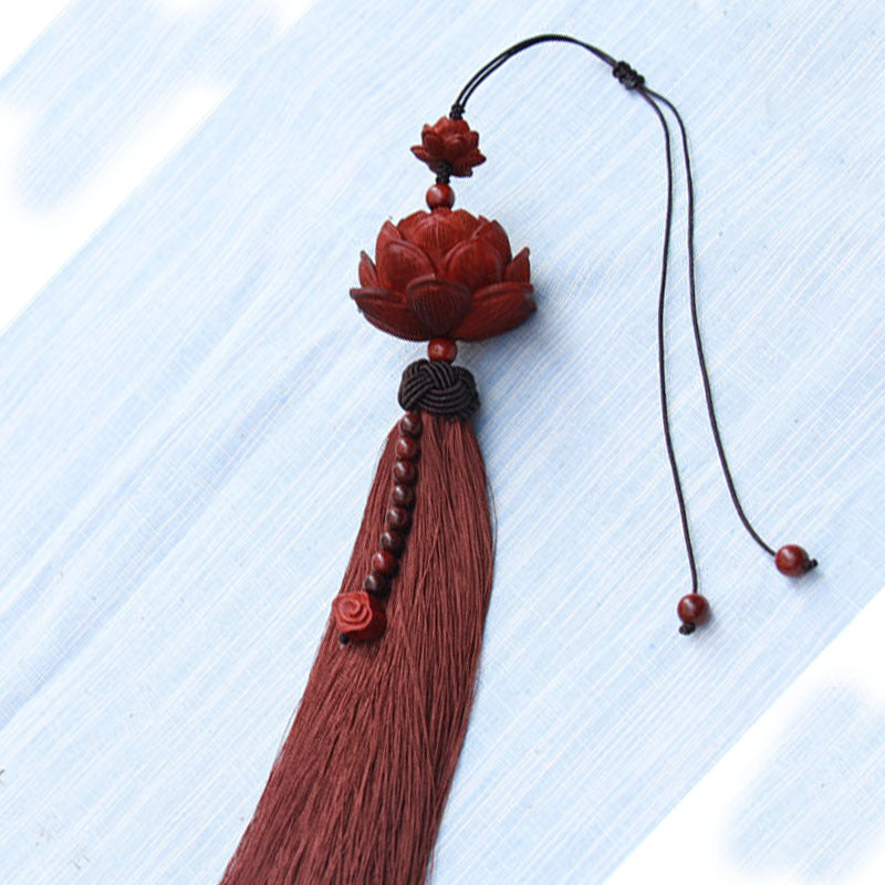 A red sandalwood lotus carving with a long matching tassel on a cord.
