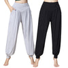 Model wearing light grey high-waisted harem pants with hand in pocket