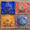 Four square embroidered Tibetan altar mats with colorful religious symbols