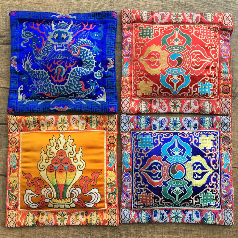 Four square embroidered Tibetan altar mats with colorful religious symbols
