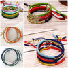 Stack of colorful hand-woven Tibetan King Kong knot bracelets on wood surface