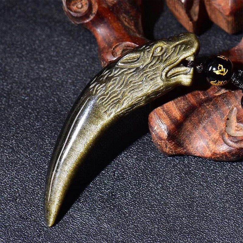 Close up side view of the carved gold obsidian wolf tooth pendant showing detailed texture.