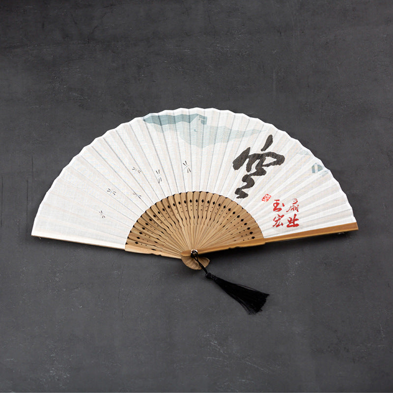 Open white folding fan with bamboo ribs and black calligraphy on a dark background