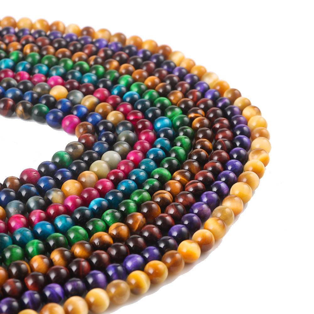 Coiled strands of colorful polished tiger eye beads on a white background