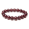 Deep red natural garnet bead bracelet on a black reflective surface