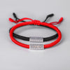Two knotted bracelets in red and black with a silver mantra bar