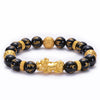 Gold-tone Pixiu charm on a black beaded bracelet with gold accents