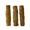 Close-up of three hand-tied cedar smudge sticks bound with red and white string