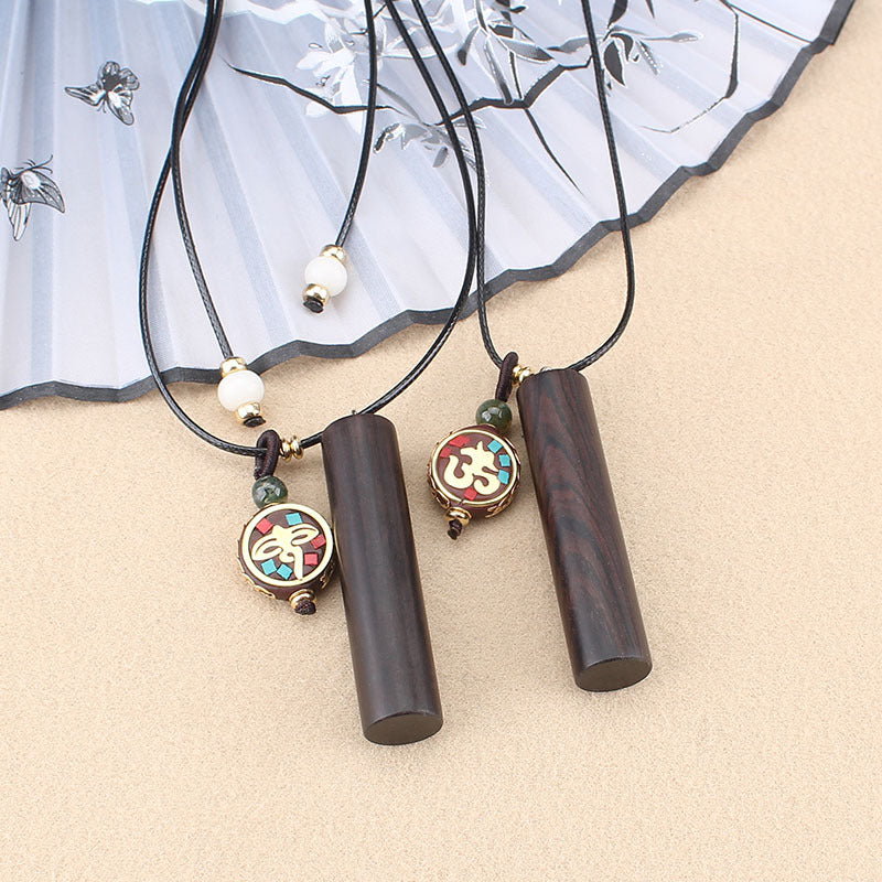 Three variations of an ebony wood cylinder necklace with colorful charms on a beige background