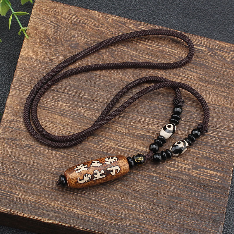 Long brown cord necklace with an oval agate pendant carved with white script characters