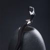 Close up of a dark wooden hairpin with silver butterfly details