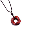 Red sandalwood twisted knot pendant on a brown braided cord