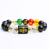 Close up of a black obsidian beaded bracelet with a rectangular zodiac charm and colorful accent beads