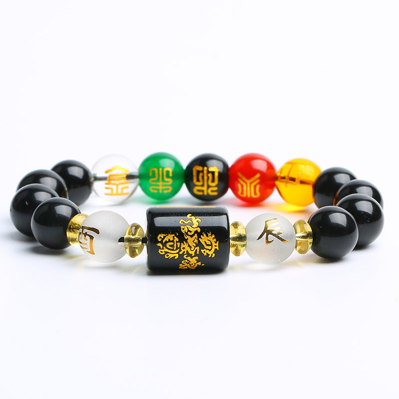 Close up of a black obsidian beaded bracelet with a rectangular zodiac charm and colorful accent beads