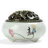White ceramic incense burner with a lotus design and metal lid