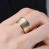 Gold-tone stainless steel spinner ring with Tibetan script on a hand