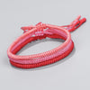 Three red and pink hand braided cord bracelets stacked together
