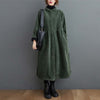 Woman wearing a dark green long sleeve corduroy coat with pockets