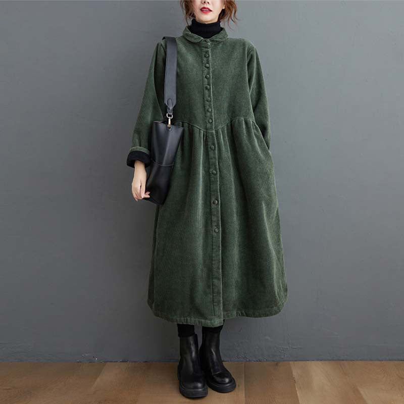 Woman wearing a dark green long sleeve corduroy coat with pockets