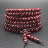 Red wooden mala bracelet with 108 beads wrapped around itself featuring a bow knot tassel