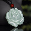 Close up of a light green jade pendant carved in the shape of a rose flower