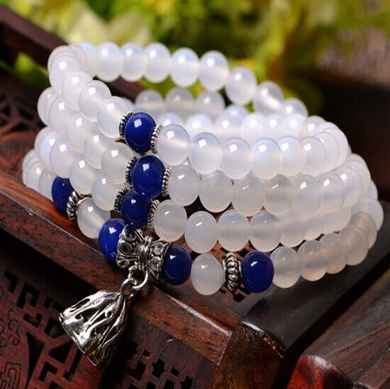 White agate mala bracelet wrapped on a wooden surface