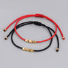 Red and black braided bracelets with three gold copper beads
