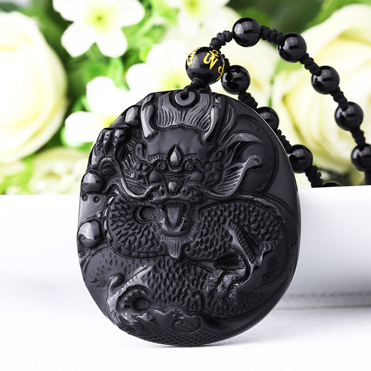 Close-up of a black stone pendant carved with a dragon design