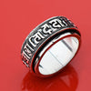 Silver tone titanium steel ring with Tibetan script on a red background