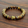 Gold tone Maitreya Buddha head bracelet with tiger eye beads on wood