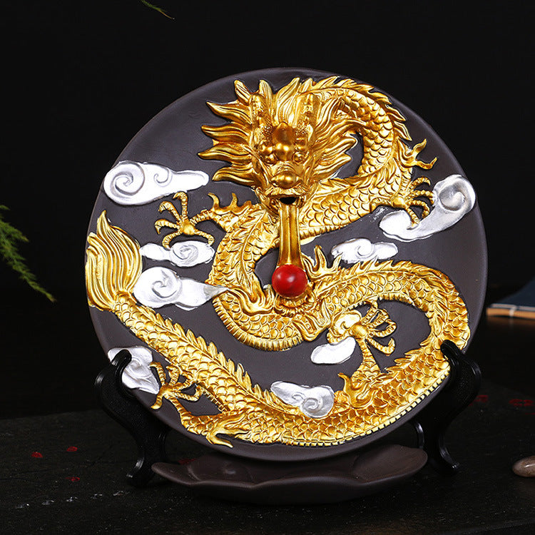 Ceramic backflow incense burner with a raised golden dragon and white clouds on a dark background