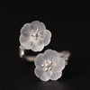 Close up of a silver adjustable ring with two white crystal plum blossoms