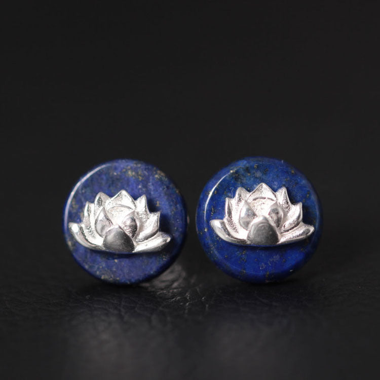 Close-up view of round blue lapis lazuli stud earrings with silver lotus flowers on top