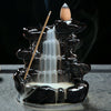 Black ceramic waterfall incense burner with white smoke cascading down tiered levels