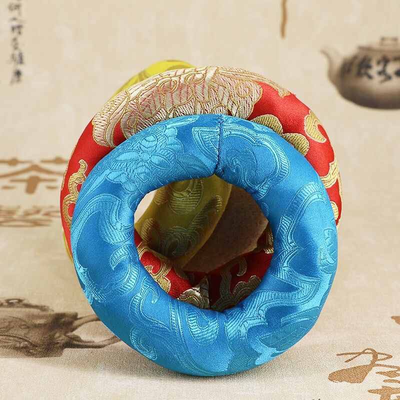 A blue embroidered fabric ring cushion resting on a surface