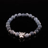 A beaded bracelet with a gold-tone leopard head charm on a dark background