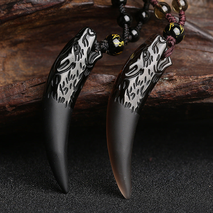 Natural ice obsidian wolf tooth pendant hanging on a brown braided cord with wooden beads