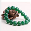 Green agate beaded bracelet resting on a pinecone